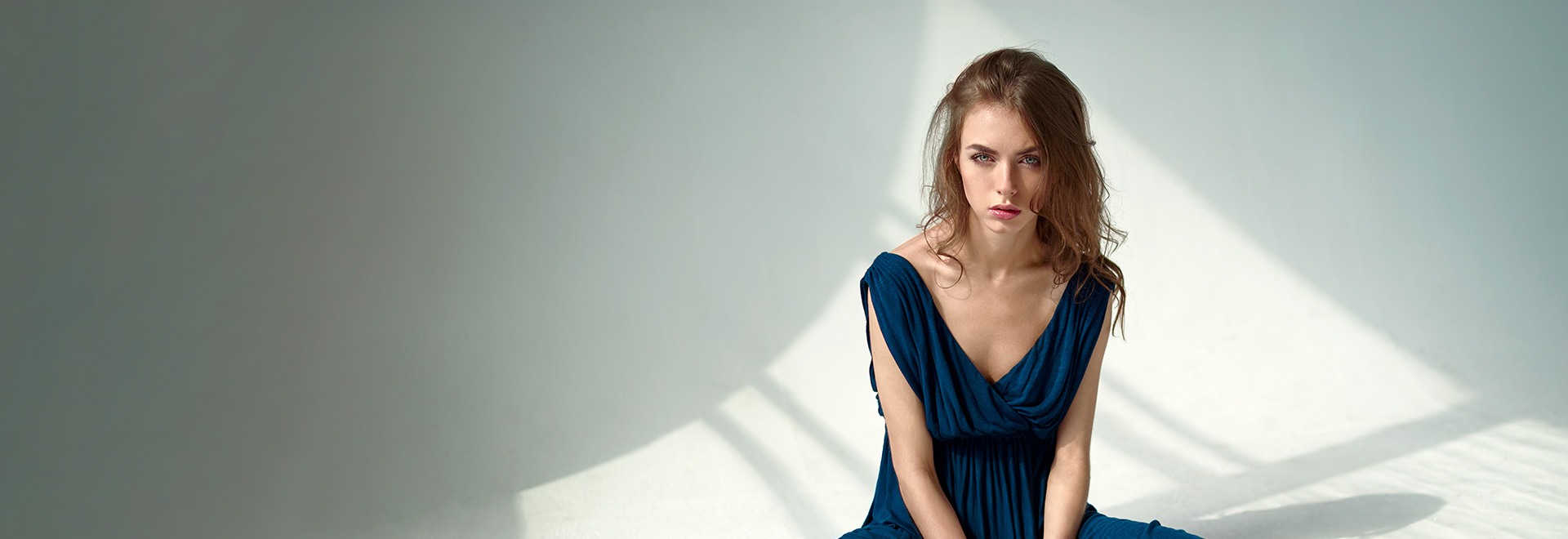 woman in blue dress with light green background