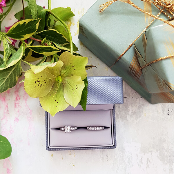 engagement rings in a box with packaging and flowers